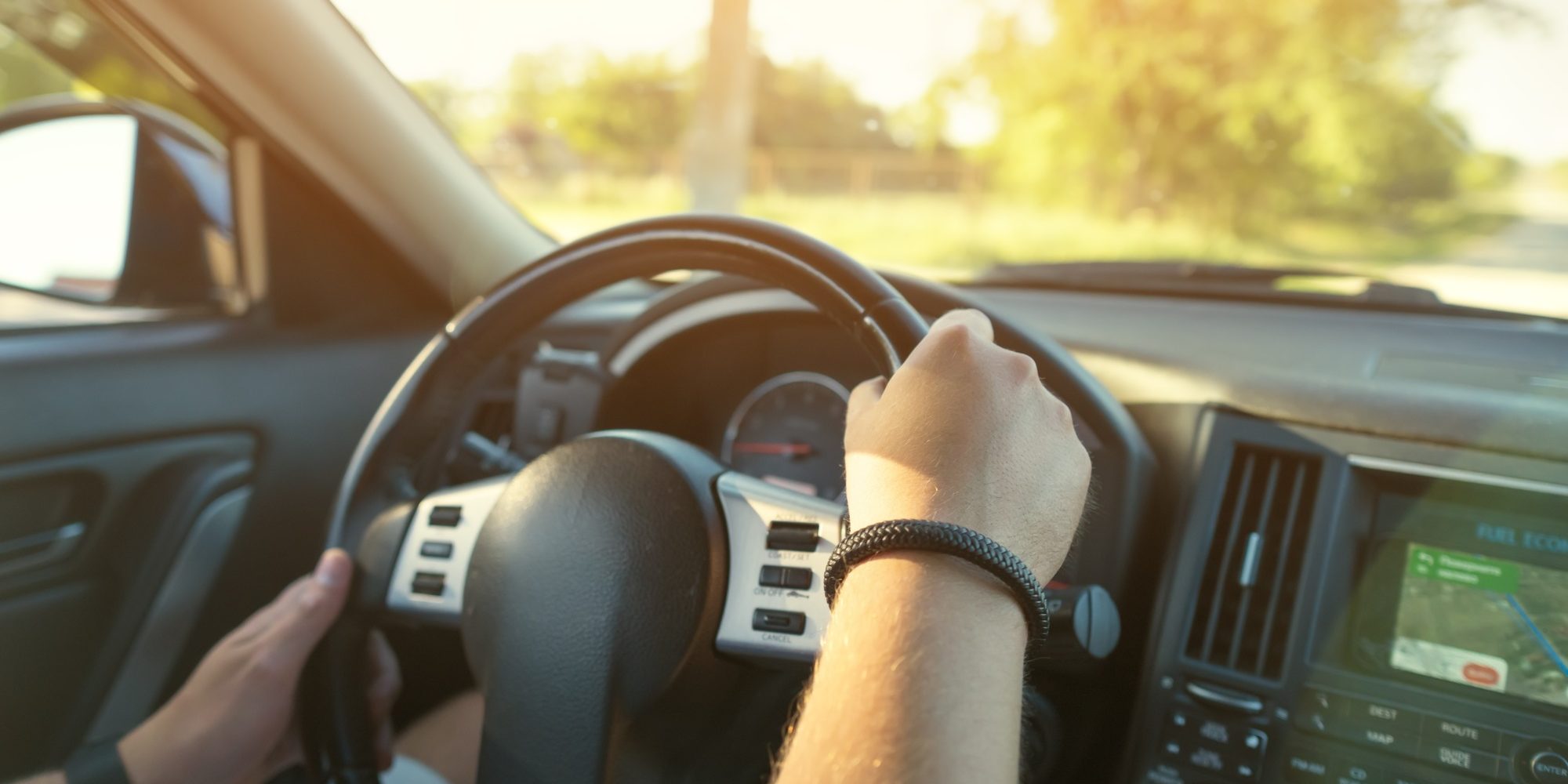 Driver's hands and car dashboard.